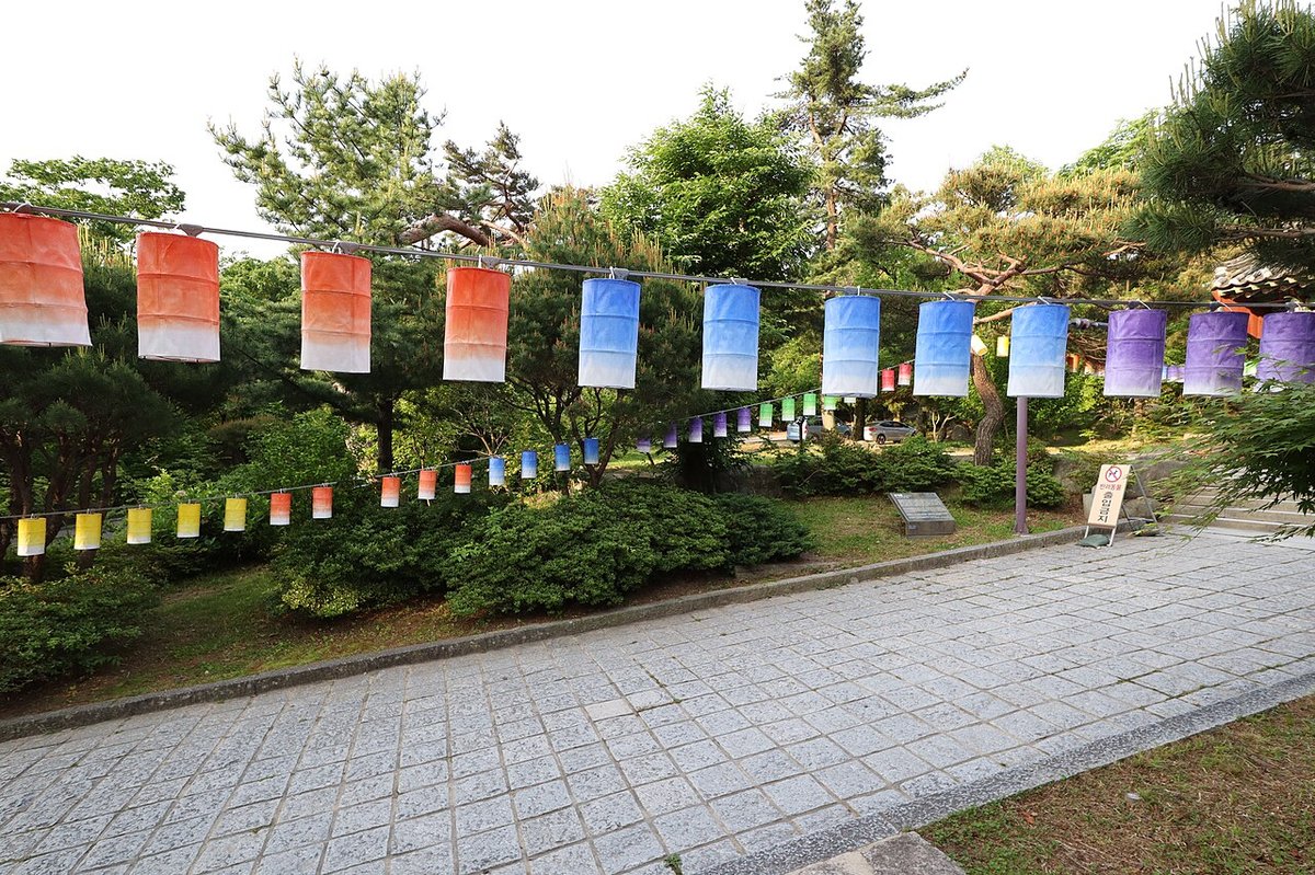 절 마당에 색색의 연등이 줄지어 걸려 있는 모습