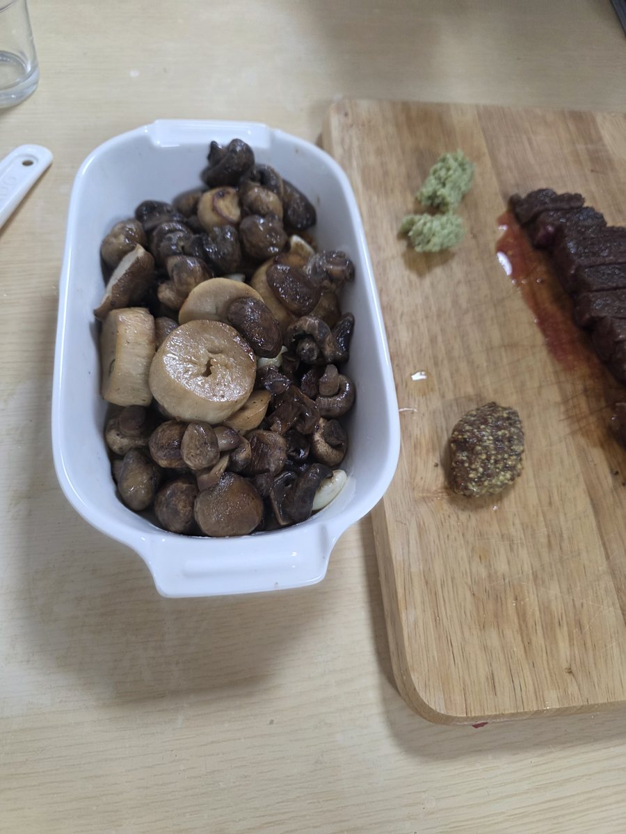 흰 그릇에 담은 버섯 구이와 도마 위 와사비, 머스터드