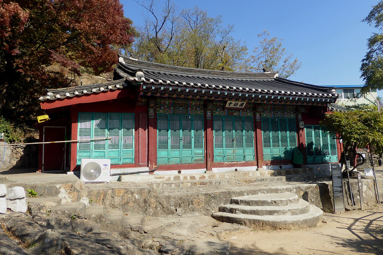 서울 인왕산 국사당 굿당 정면. 기와지붕 아래 붉은 기둥과 청록색 창살문이 보인다