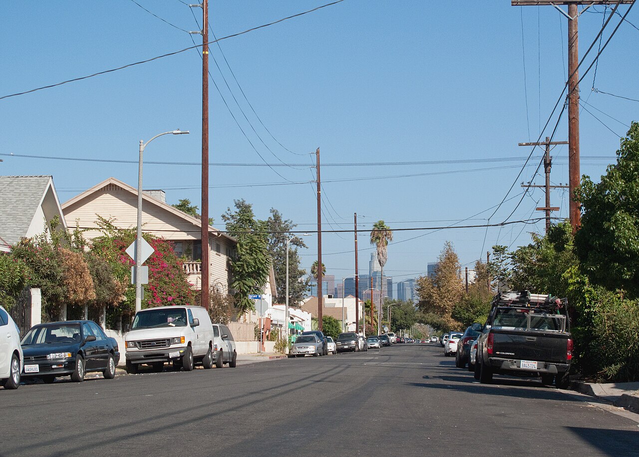 A residential street in the Los Angeles area with the downtown skyline in the distance