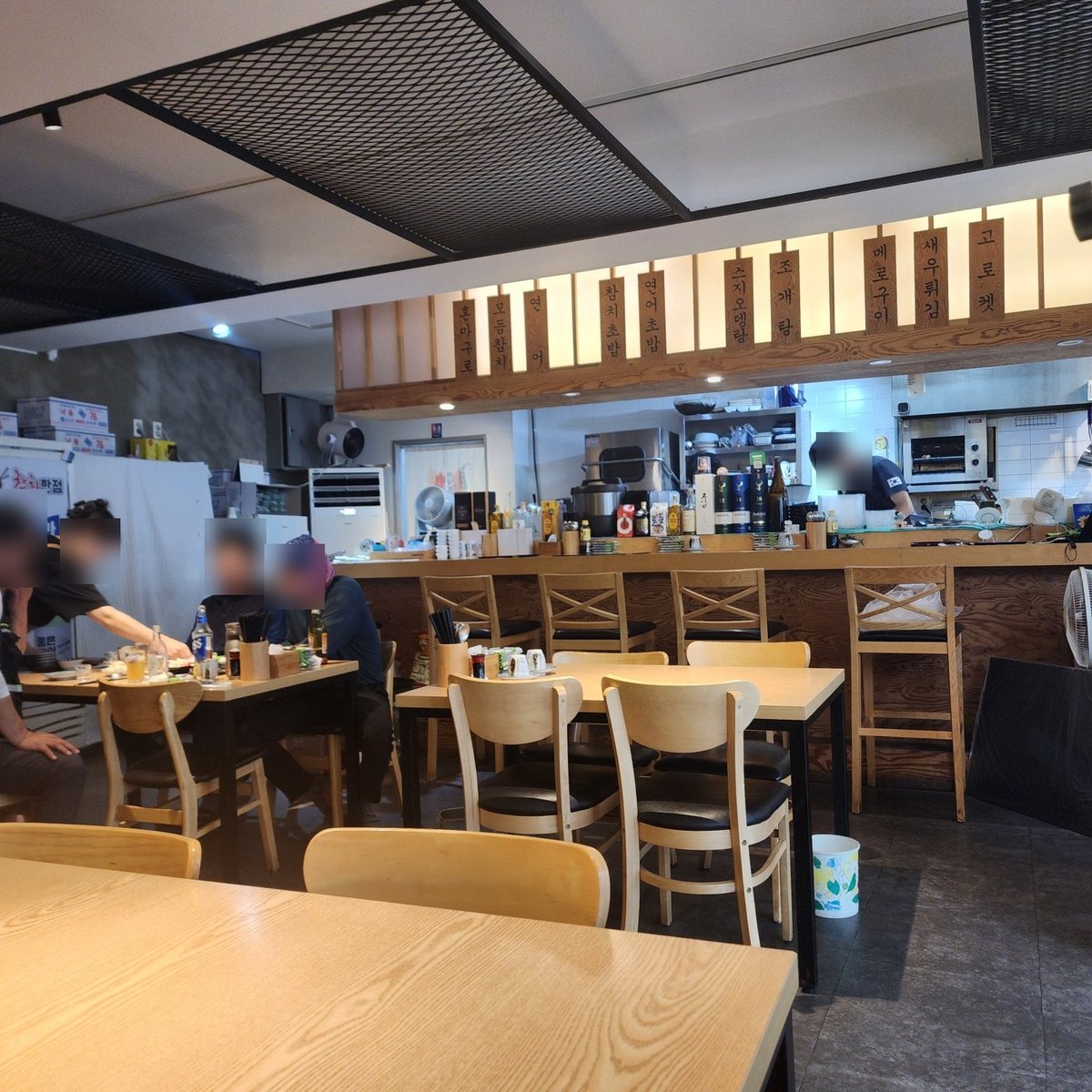 참치한점 매장 내부, 오픈 주방 위에 혼마구로·모둠참치·스지오뎅탕·메로구이 등이 적힌 나무 메뉴 간판이 걸려 있다