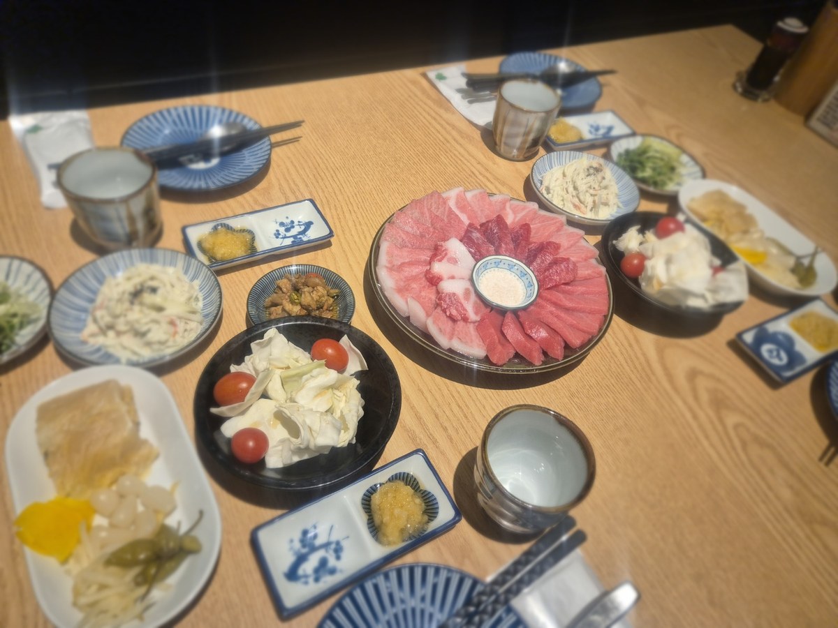 연산동 토곡 참치한점 상 전체를 옆에서 본 모습, 참치 접시를 둘러싸고 종지와 반찬 접시가 상을 덮고 있다