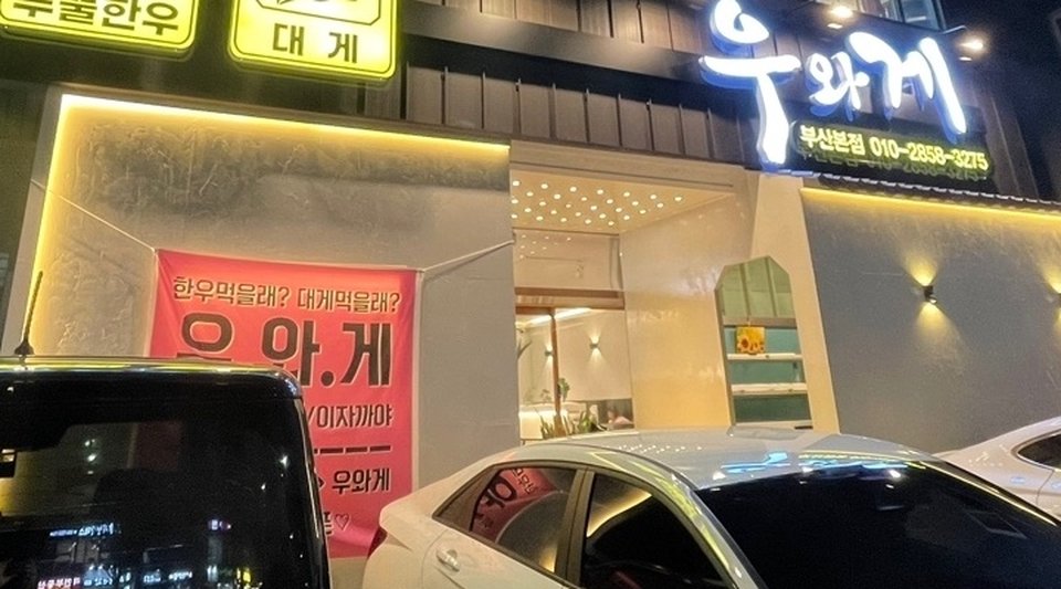 우와게 입구, 한우먹을래 대게먹을래라고 적힌 빨간 현수막과 우와게 부산본점 간판