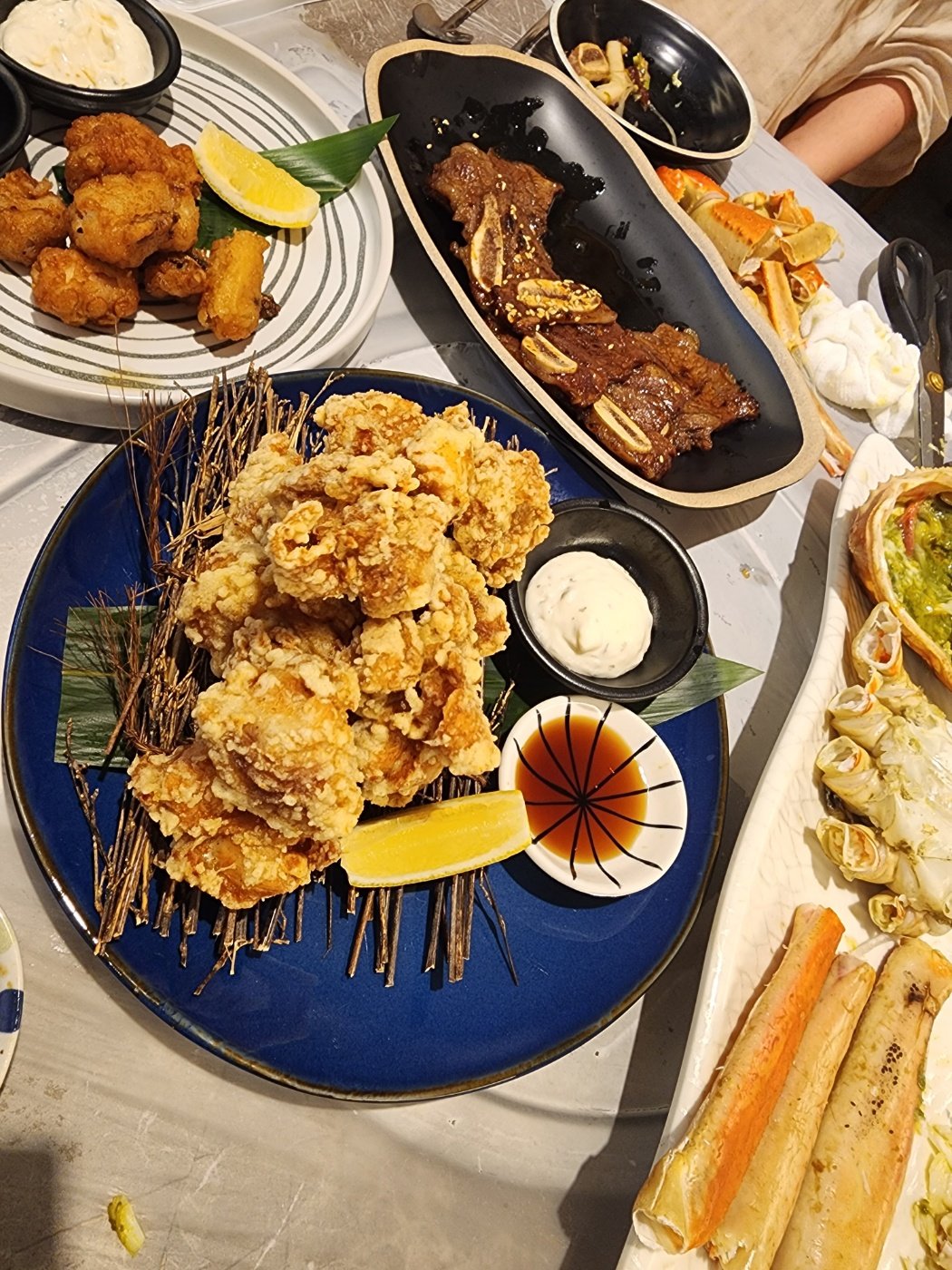 우와게 치킨 가라아게와 LA갈비, 대게 다리가 함께 놓인 테이블